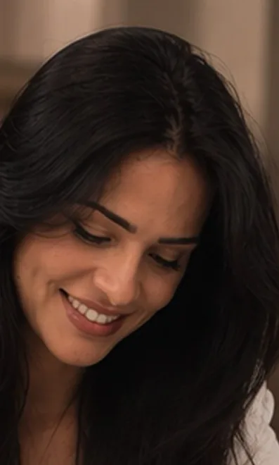 Ana Paula Teles escrevendo, olhando para baixo e sorrindo